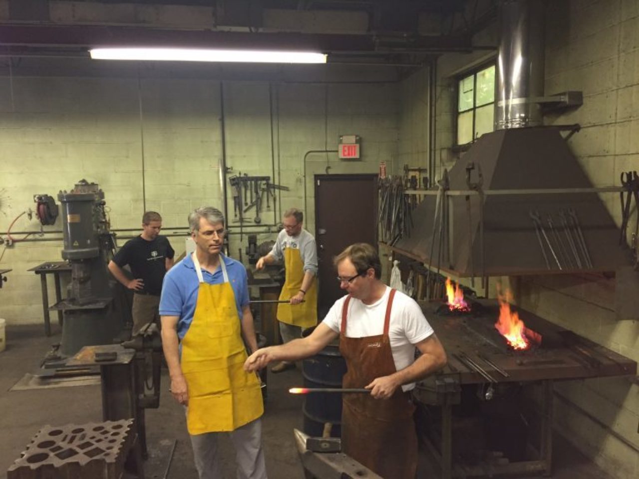 Close shows Foster Lyons how to forge iron.