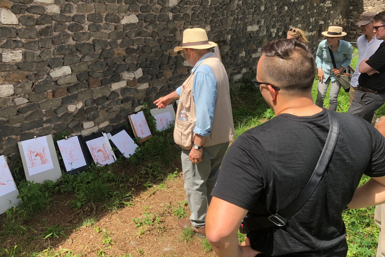 Tour participants review their sanguine pencil drawings of the Arch of Drusus