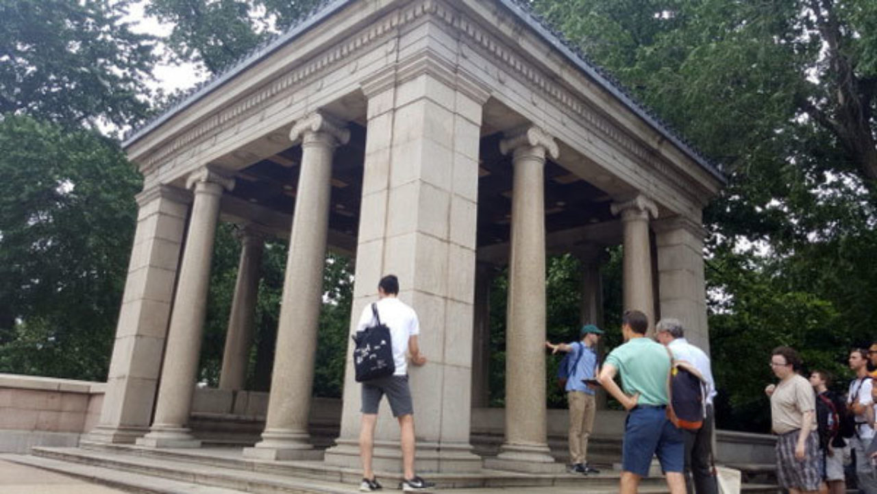 Students study a pavilion featuring ionic columns