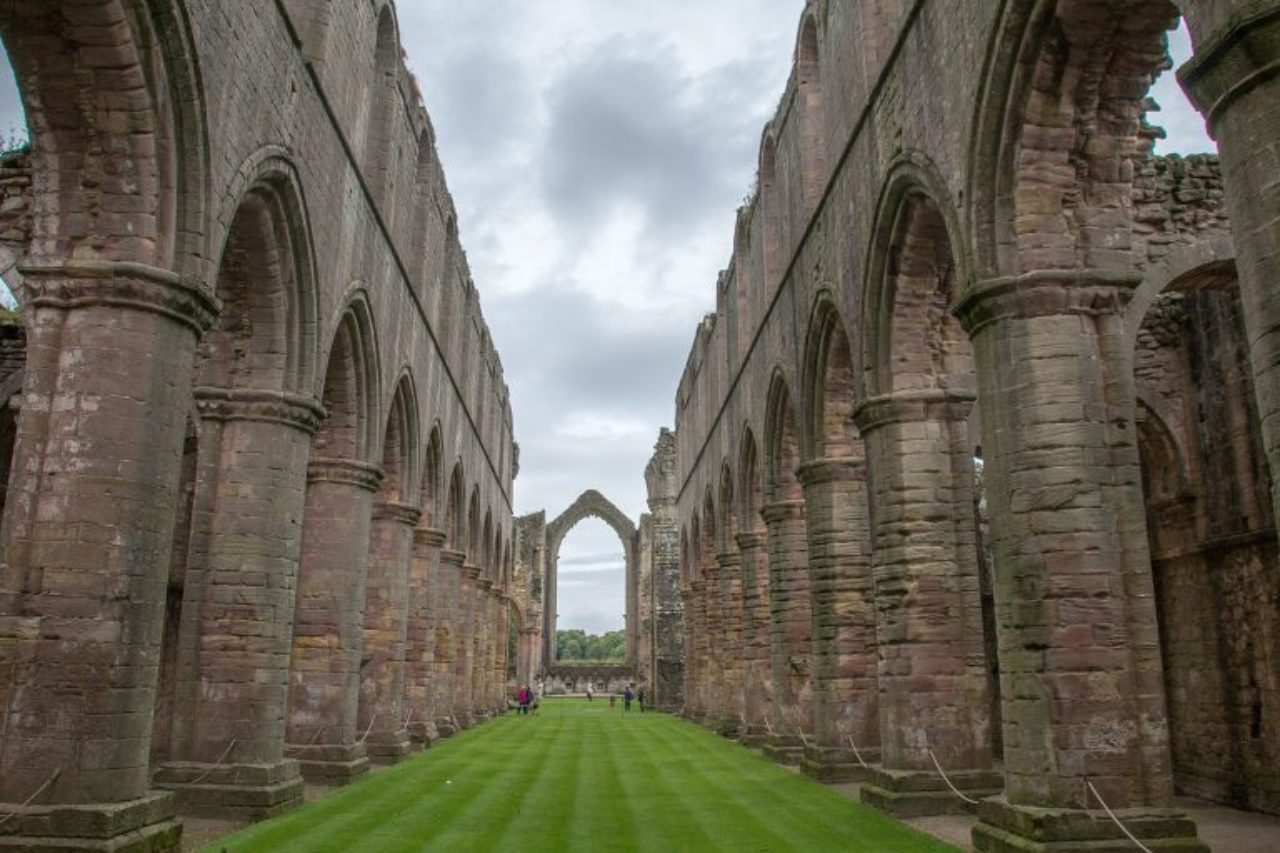 The ruins of Fountains Abbey, a former Cistercian monastery originally founded in the 12th Century (Image Source: Wikipedia / Mike Peel)