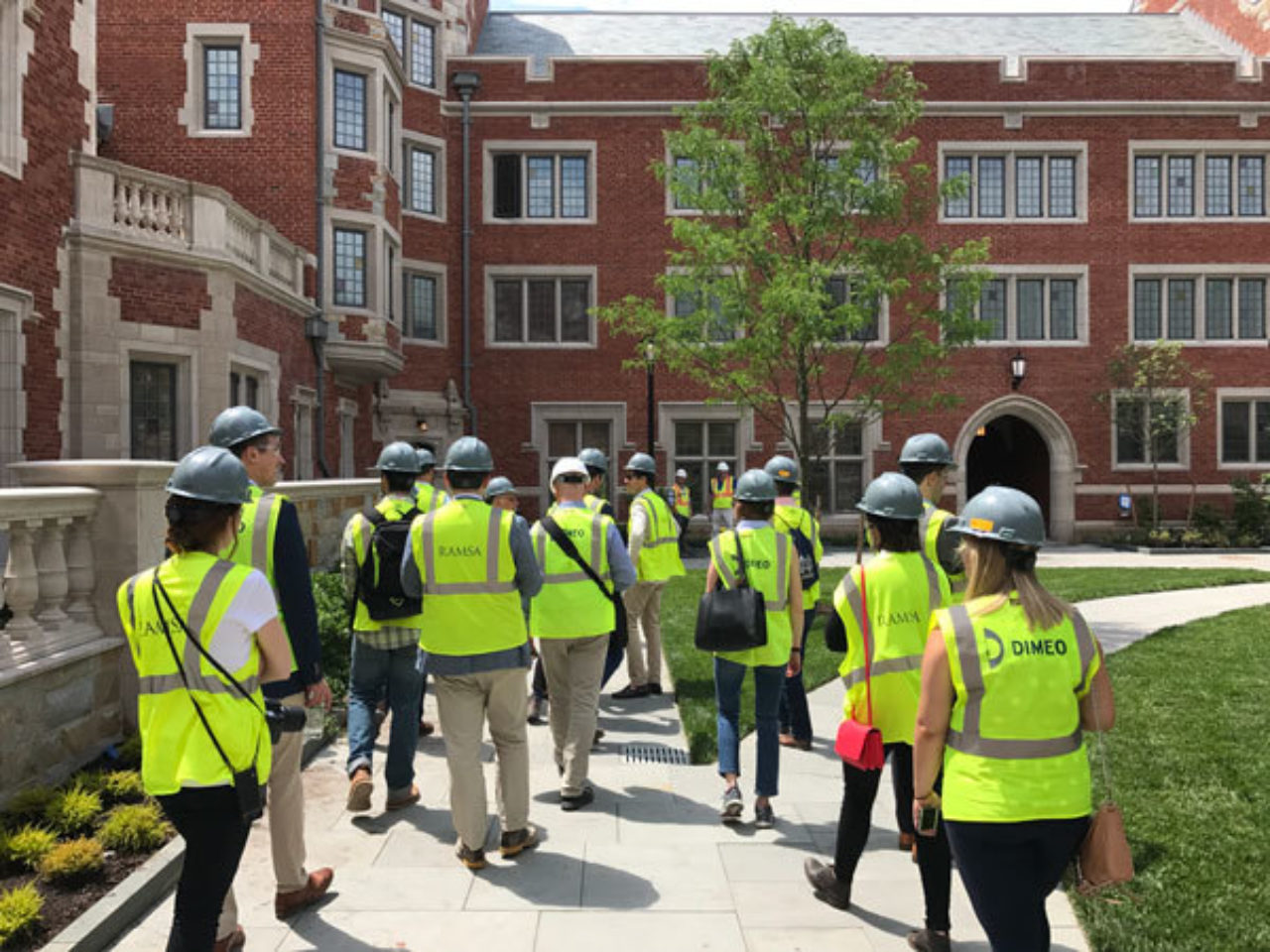 Tour participants cross through a courtyard while touring the new residential colleges